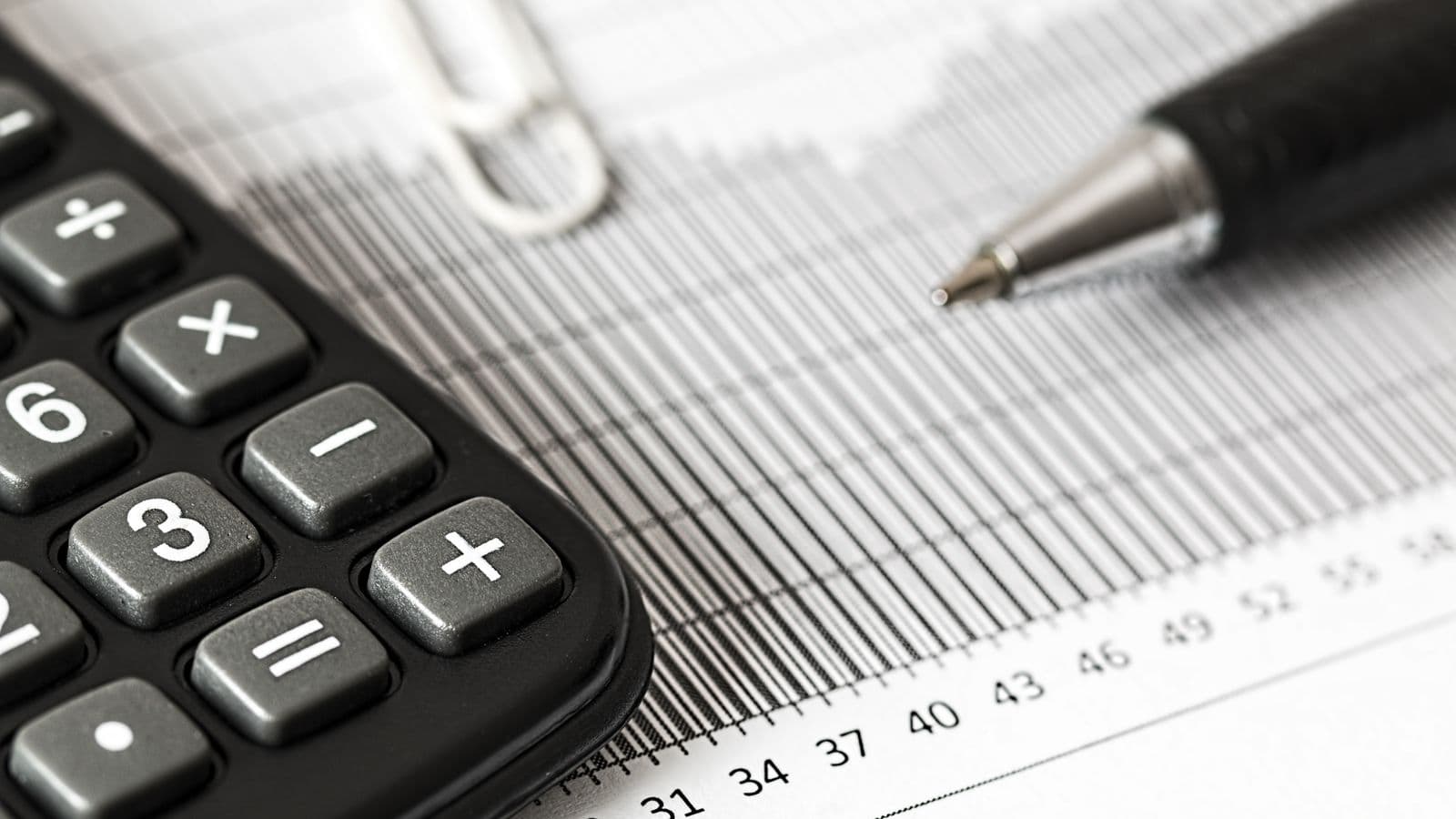Calculadora y lápiz sobre una planilla de datos para calcular pagos provisionales mensuales