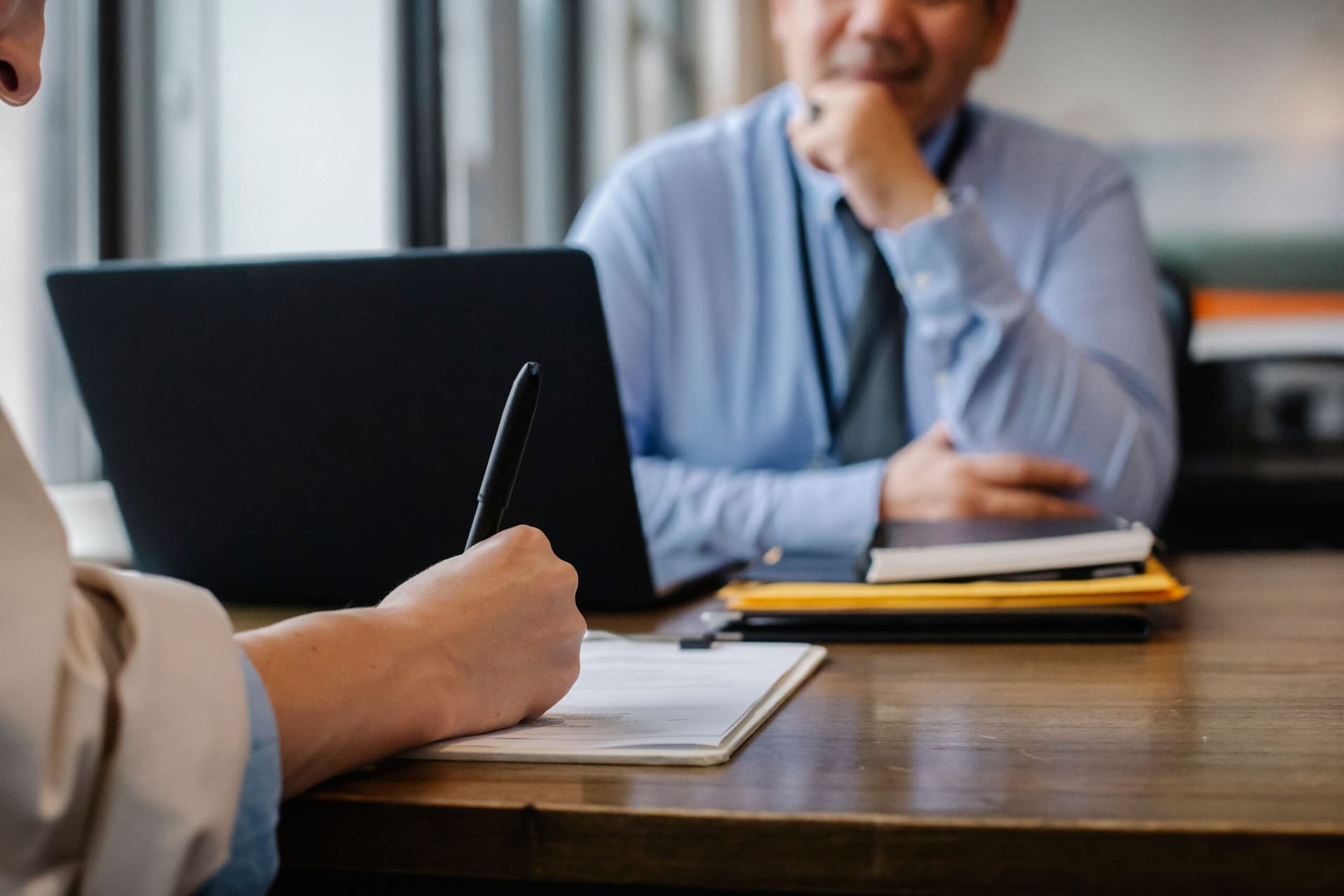 Persona firmando un contrato comercial con cláusulas de garantías, seguros y responsabilidad civil en una empresa en Chile